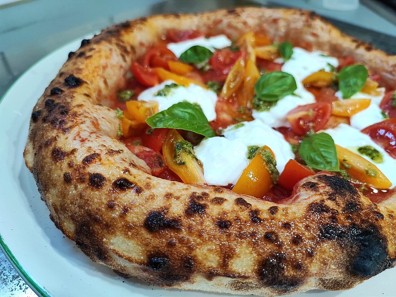 Pizza con pomodorini rossi e gialli e mozzarella di bufala